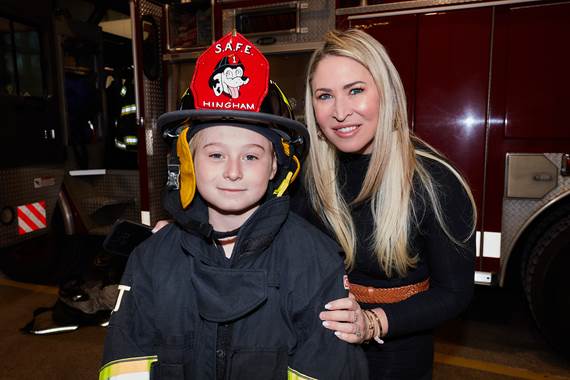 Mother with girl wearing fire helmet